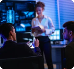 Três profissionais conversando em uma reunião de negócios, representando a etapa de atração de clientes.